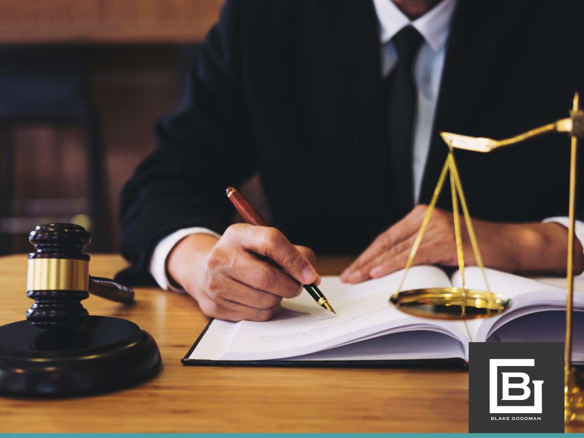 An attorney writing on legal documents, with a gavel and scales of justice on the desk, representing guidance on Debt Management & Chapter 13 Bankruptcy.