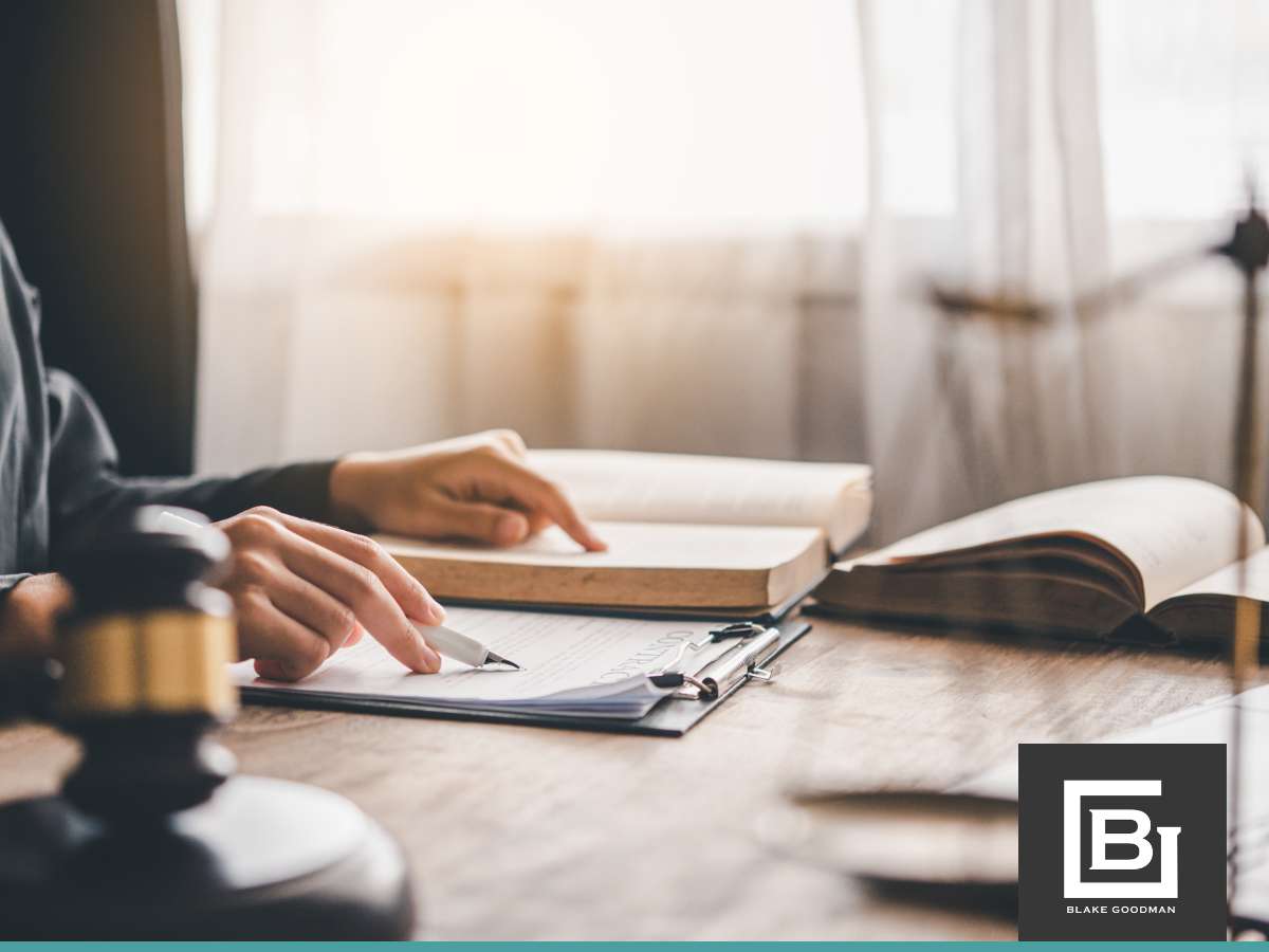 A person reviewing documents with a gavel on the table, symbolizing the review of mortgage applications