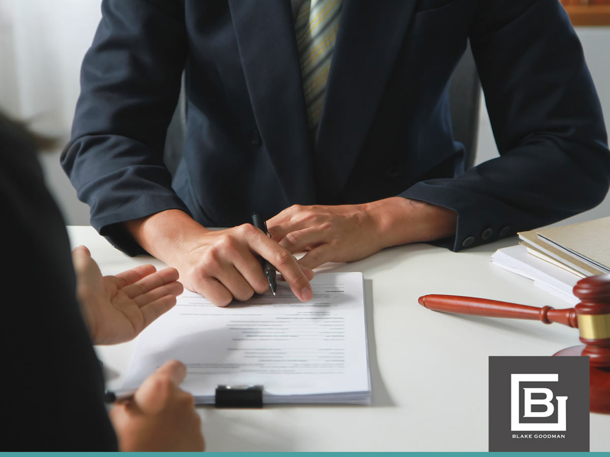 A lawyer points at a document during a bankruptcy process consultation, explaining legal details to a client